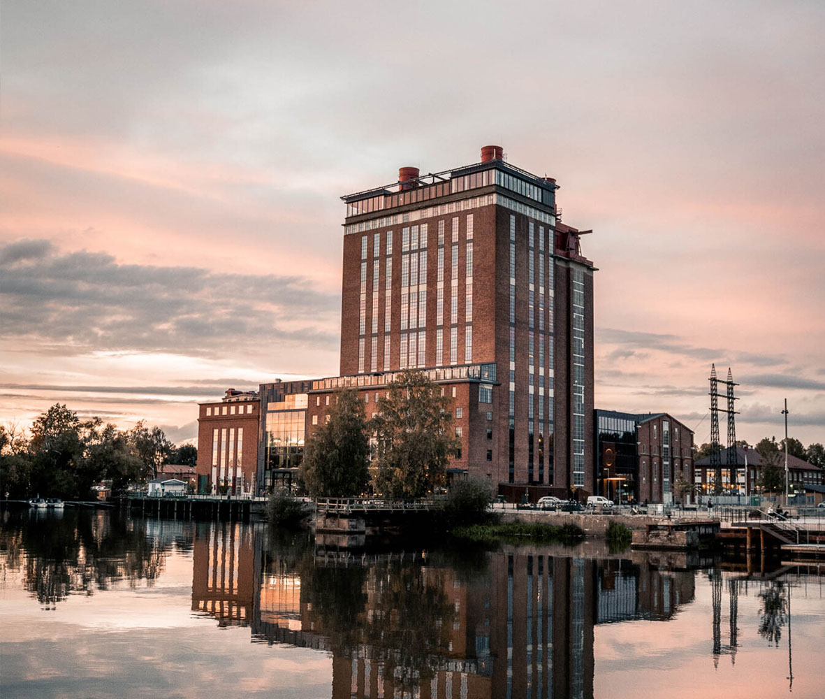 The Steam Hotel vid vatten med spegling i solnedgång
